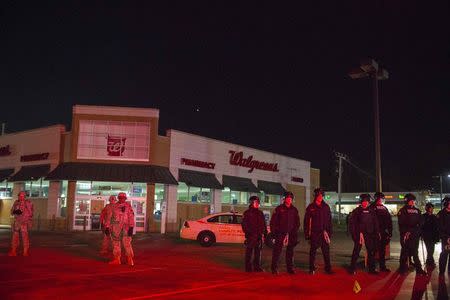 National Guard troops and police officers guard a Walgreens store from protesters during a second night of protests in Ferguson, Missouri November 25, 2014. REUTERS/Lucas Jackson