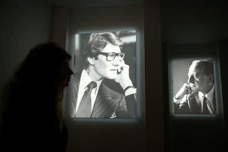 A visitor walks past photographs of Yves Saint Laurent and Pierre Berge at the Yves Saint Laurent Museum in Paris, France, September 27, 2017. The new museum, celebrating the life and work of French designer Yves Saint Laurent (1936-2008), will open at the avenue Marceau address of his former work studio for almost 30 years. Picture taken September 27, 2017. REUTERS/Stephane Mahe