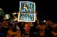 A demonstrator holds a sign during protest over alleged police brutality in Lagos