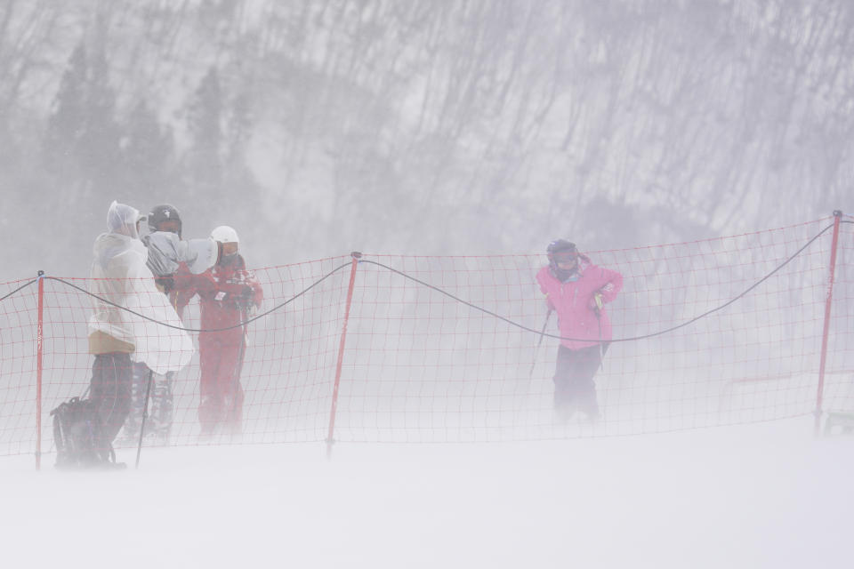 People look at the course under bad weather as they wait to see if the men's slalom competition will take place during the 2020 Audi FIS Alpine Ski World Cup at Naeba Ski Resort in Yuzawa, Niigata prefecture, northern Japan, Sunday, Feb. 23, 2020. (AP Photo/Christopher Jue)