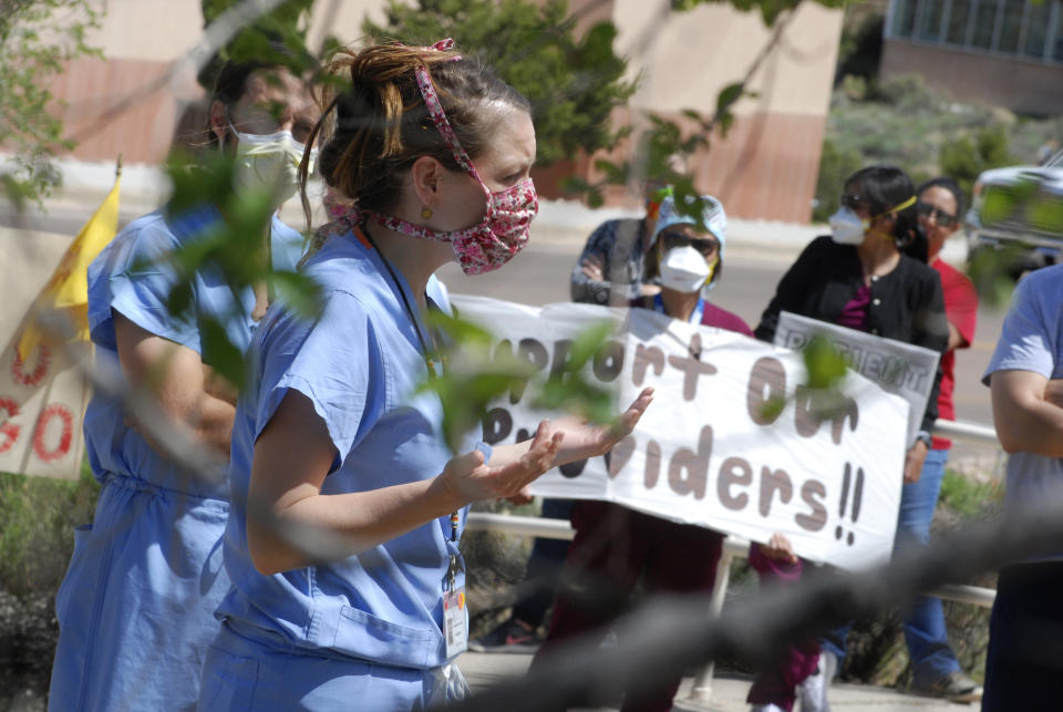 In this photo taken May 8, 2020, medical staff from Rehoboth McKinley Christian Hospital hold a protest over working conditions and depleted staff in Gallup, N.M. Many nurses and doctors say staffing at the hospital was inadequate because of hospital CEO David Conejo's move to cut back on nurses in the first week of March to offset declining hospital revenues after elective surgeries were suspended. They voiced their discontent at the recent protest calling for his resignation. (AP Photo/Morgan Lee)