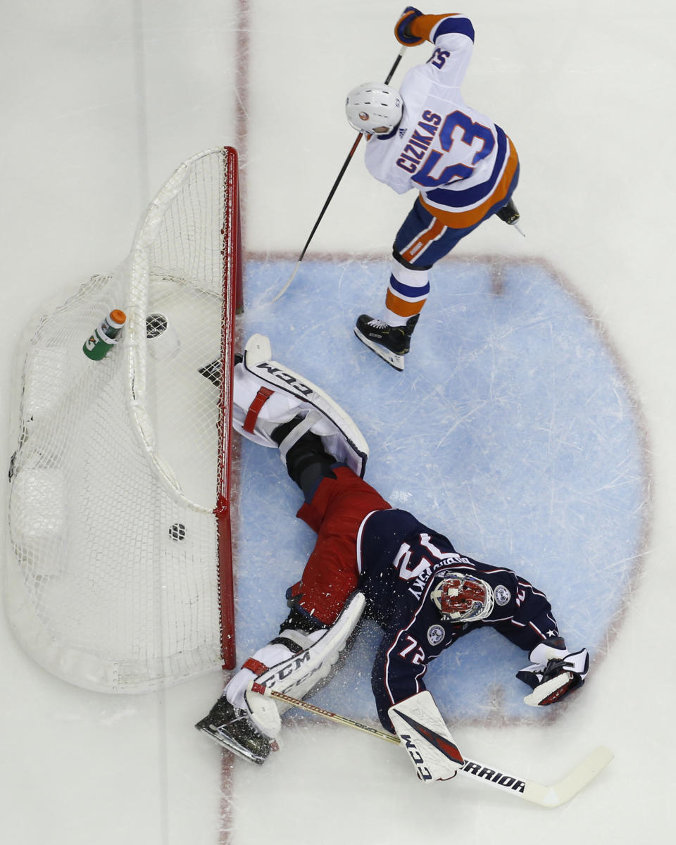 New York Islanders' Casey Cizikas, top, scores a goal against Columbus Blue Jackets' Sergei Bobrovsky, of Russia, during the first period of an NHL hockey game Thursday, Feb. 14, 2019, in Columbus, Ohio. (AP Photo/Jay LaPrete)