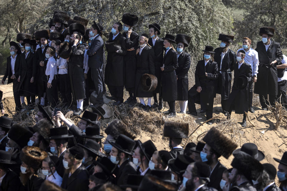 Ultra-Orthodox Jews attend the funeral for Rabbi Mordechai Leifer, as Israeli police try to control the crowd of mourners, the latest in a string of clashes between security forces and ultra-Orthodox Jews violating a national coronavirus lockdown order, in the port city of Ashdod, Israel, Monday, Oct. 5, 2020. Repeated lockdown violations by segments of the ultra-Orthodox population have confounded public health experts and tested Prime Minister Benjamin Netanyahu's longstanding political alliance with religious leaders. (AP Photo/Tsafrir Abayov)