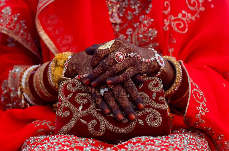 FILE PHOTO: Jewellery is seen on a bride's hand as she holds a purse during a mass marriage ceremony, in which, 51 Muslim couples took their wedding vows, in Mumbai,
