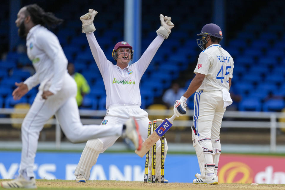 West Indies' keeper Joshua Da Silva celebrates the dismissal of India's captain Rohit Sharma, right, bowled by Jomel Warrican , left, on day one of their second cricket Test match at Queen's Park in Port of Spain, Trinidad and Tobago, Thursday, July 20, 2023. (AP Photo/Ricardo Mazalan)