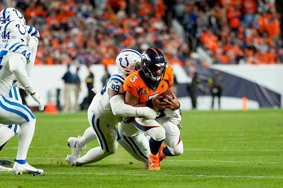 Denver Broncos quarterback Russell Wilson is tackled by Indianapolis Colts defensive tackle DeForest Buckner in Thursday's game.