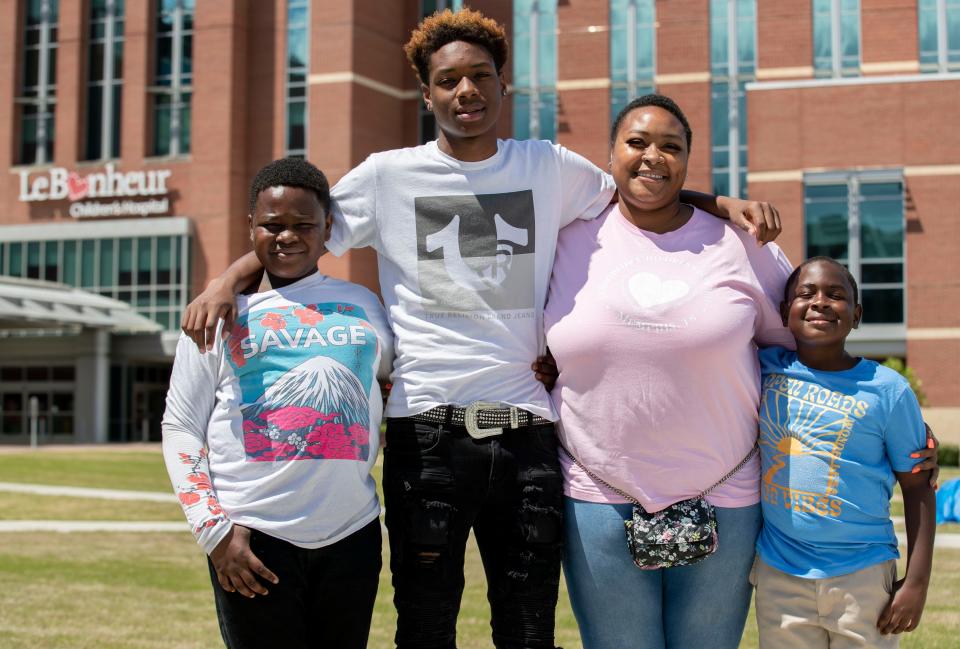 Anjelica Parker stands with her sons Khaidyn Parker, 8, Christopher Warmsley III, 11, and Donovan Coleman, 16, outside Le Bonheur Children's Hospital on May 6, 2022, in Memphis. Anjelica Parker works at the hospital after going through a local program that takes underemployed medical district residents and helps upskill them for jobs. 