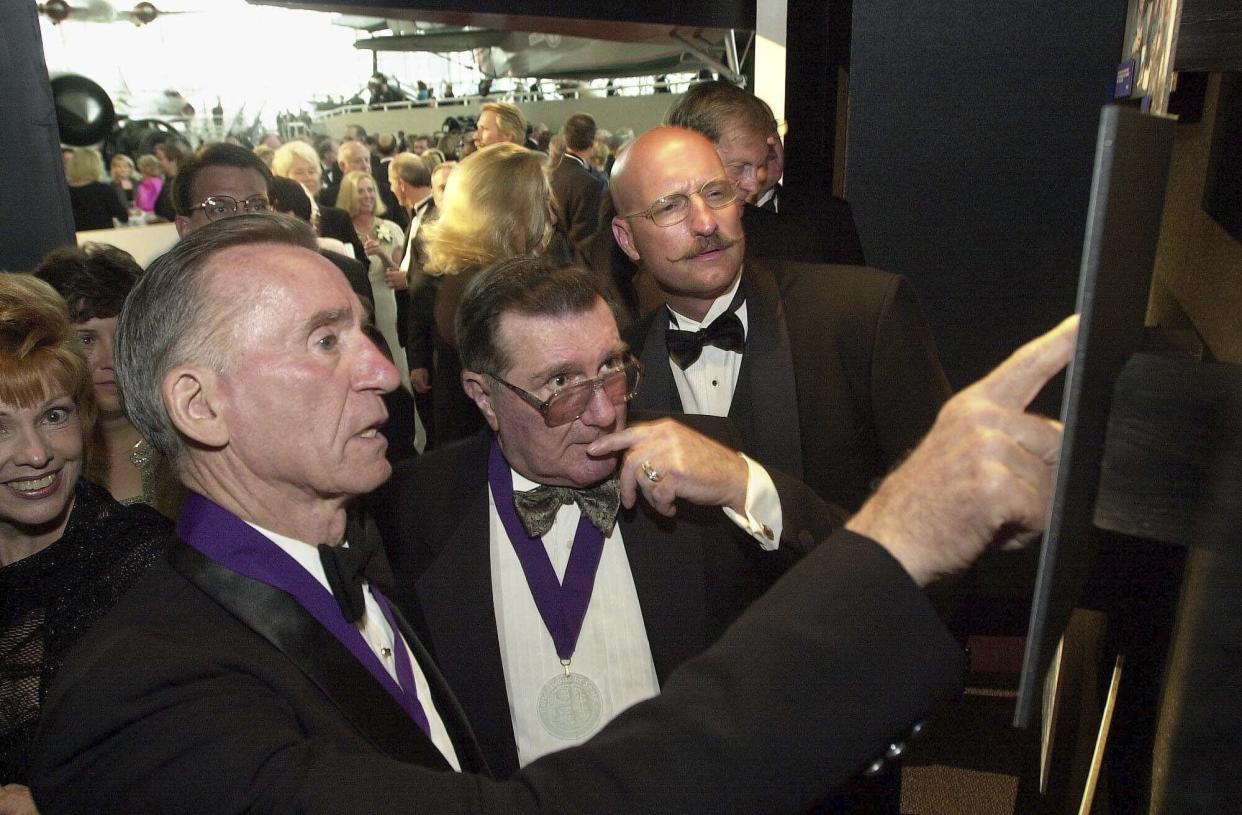 FILE - Apollo 7 astronaut Walter Cunningham, left, points to pictures of fellow astronaut the late Charles "Pete" Conrad while speaking with Apollo 10 astronaut Dick Gordon, center, and Andy Conrad, the son of Charles Conrad, at the opening of the Rendezvous in Space exhibit at the Museum of Flight in Seattle, Wash., July 22, 2000. Cunningham, the last surviving astronaut from the first successful crewed space mission in NASA's Apollo program, has died. He was 90. (AP Photo/Jay Drowns, File)