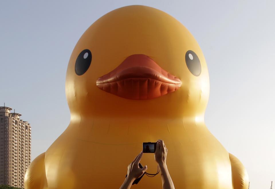 A man takes a picture of the "Rubber Duck" by Dutch conceptual artist Florentijn Hofman while it is on display at Kaohsiung Harbor, southern Taiwan, September 19, 2013. REUTERS/Pichi Chuang