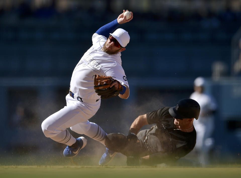 Los Angeles Dodgers second baseman Max Muncy falls while looking to throw to first after New York Yankees' Brett Gardner ran into him, on a grounder hit by Gio Urshela during the ninth inning of a baseball game in Los Angeles, Saturday, Aug. 24, 2019. The Dodgers won 2-1. (AP Photo/Kelvin Kuo)