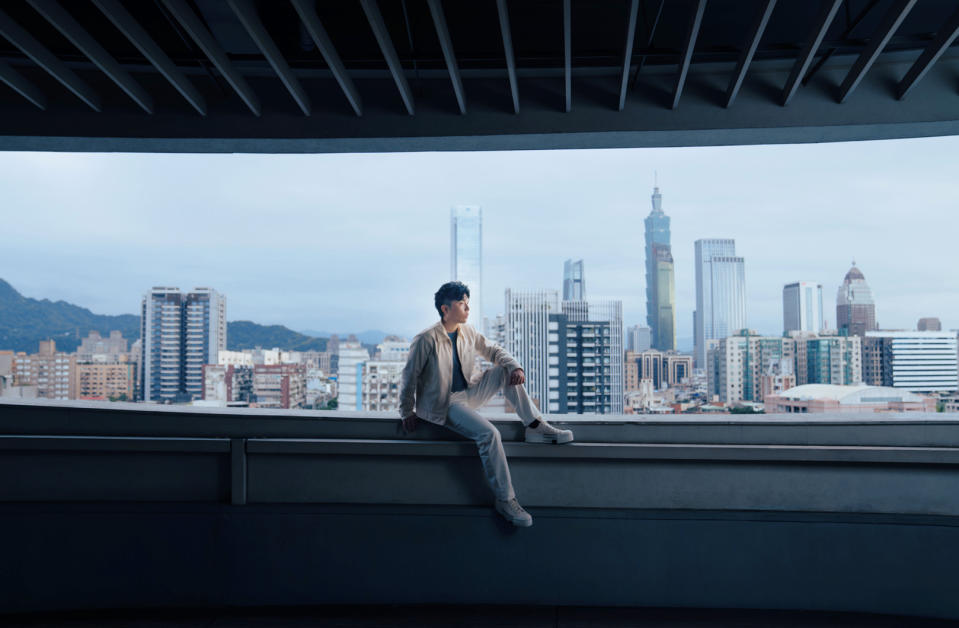 ▲小宇坐在高台上居高臨下，背景恰巧呼應歌詞「日暮到清晨，越過天際線」的畫面。