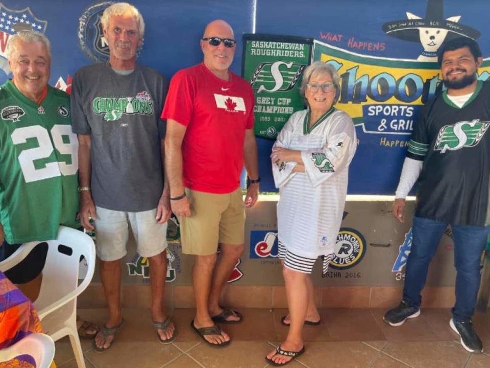 Greg Bennett, middle, owns Shooters Bar and Grill in San José del Cabo, Mexico. He says Roughriders fans are the most prominent CFL fans in San José del Cabo. (Submitted by Greg Bennett - image credit)