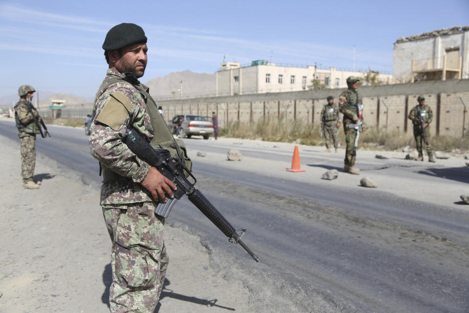 In this Wednesday, Oct. 17, 2018, photo, Afghan National Army soldiers stand guard at a checkpoint in Kabul, Afghanistan. The Taliban welcomed the news of the U.S. plan to withdraw half its troops in Afghanistan by the summer, while Afghan generals warned Friday Dec. 21, 2018, it would be a blow to the morale of the country's beleaguered security forces, who come under daily attacks from the insurgent fighters. (AP Photo/Rahmat Gul)