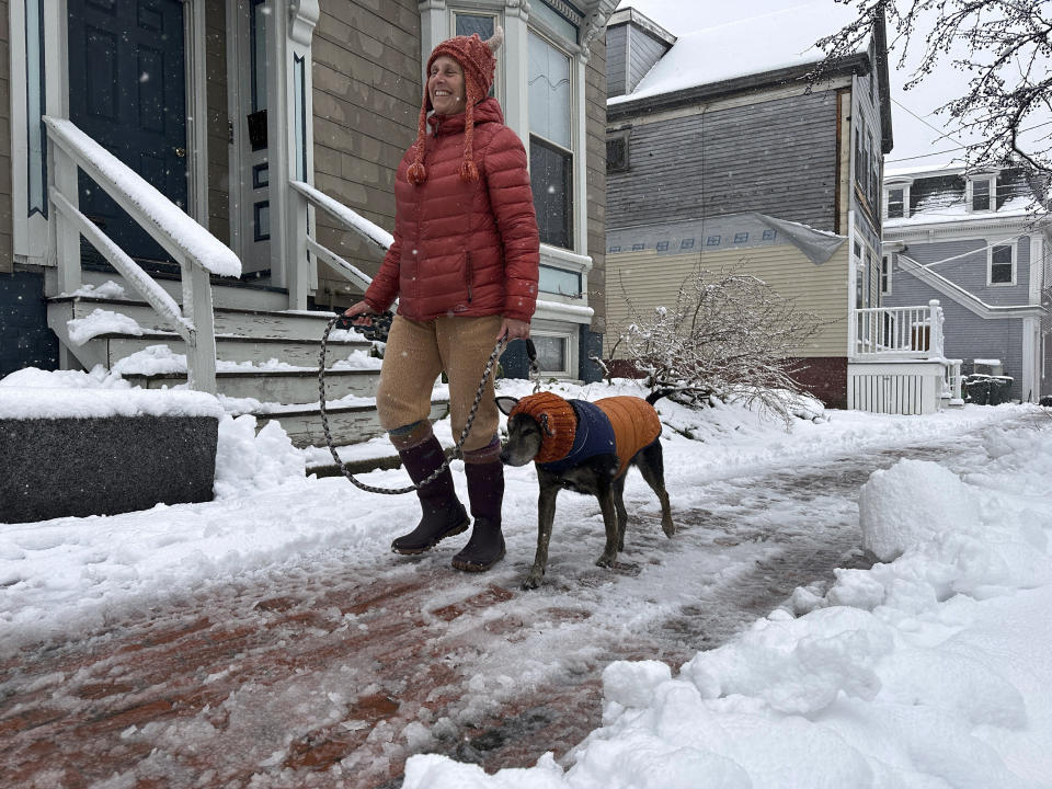 Lisa Silverman walks her dog Riley after an early-spring Nor'easter on Thursday, April 4, in Portland, Maine. (AP Photo/David Sharp)