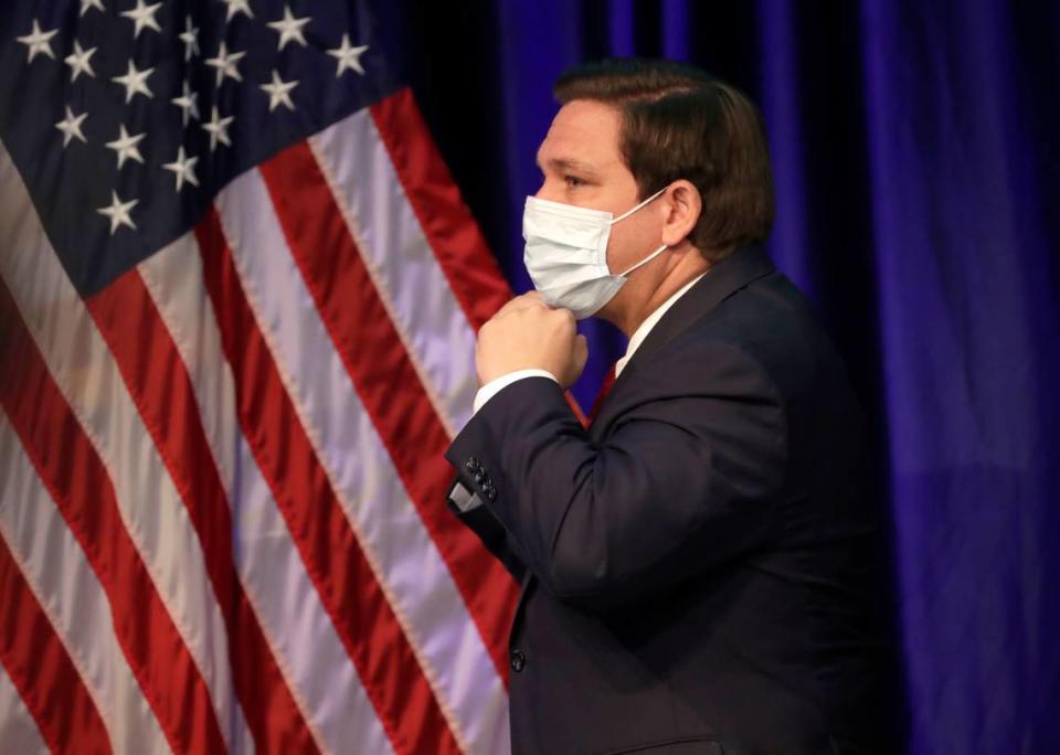 Florida Gov. Ron DeSantis puts on his mask to protect against the new coronavirus as he leaves a news conference on COVID-19, Friday, June 19, 2020, at Florida International University in Miami. 
