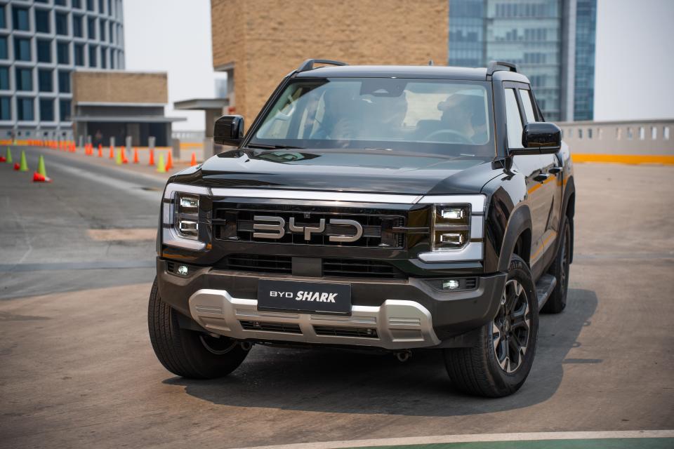 A black BYD Shark Hybrid pickup truck during a product demonstration drive at the BYD launch event in Mexico.