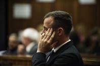 South African Olympic and Paralympic athlete Oscar Pistorius sits in the dock during his murder trial in the North Gauteng High Court in Pretoria April 16, 2014. Pistorius is on trial for murdering his girlfriend Reeva Steenkamp at his suburban Pretoria home on Valentine's Day last year. REUTERS/GianluigiI Guercia/Pool (SOUTH AFRICA - Tags: SPORT CRIME LAW ATHLETICS)