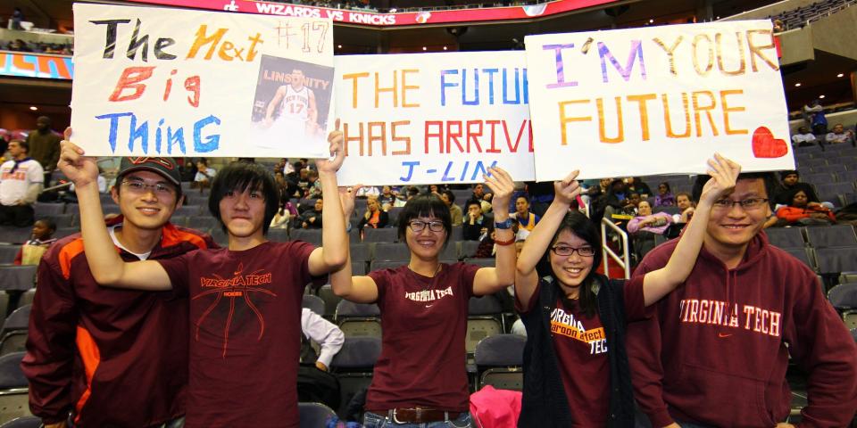 Fans in Virginia Tech sweatshirts hold up signs for Jeremy Lin in 2012.