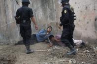 <p>Riot police detain men during a land eviction in Lima, Peru, in May 2015. Hundreds of people were squatting on land that, according to the Ministry of Culture, is an archaeological site. </p>