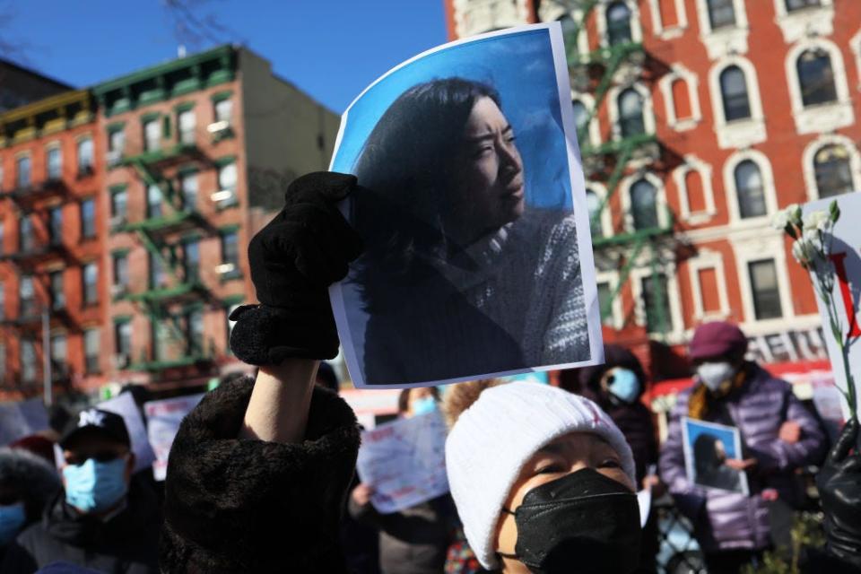 A person holds a photo of Christina Yuna Lee as people gather for a rally protesting violence against Asian Americans on Feb. 14, 2022 in New York's Chinatown.