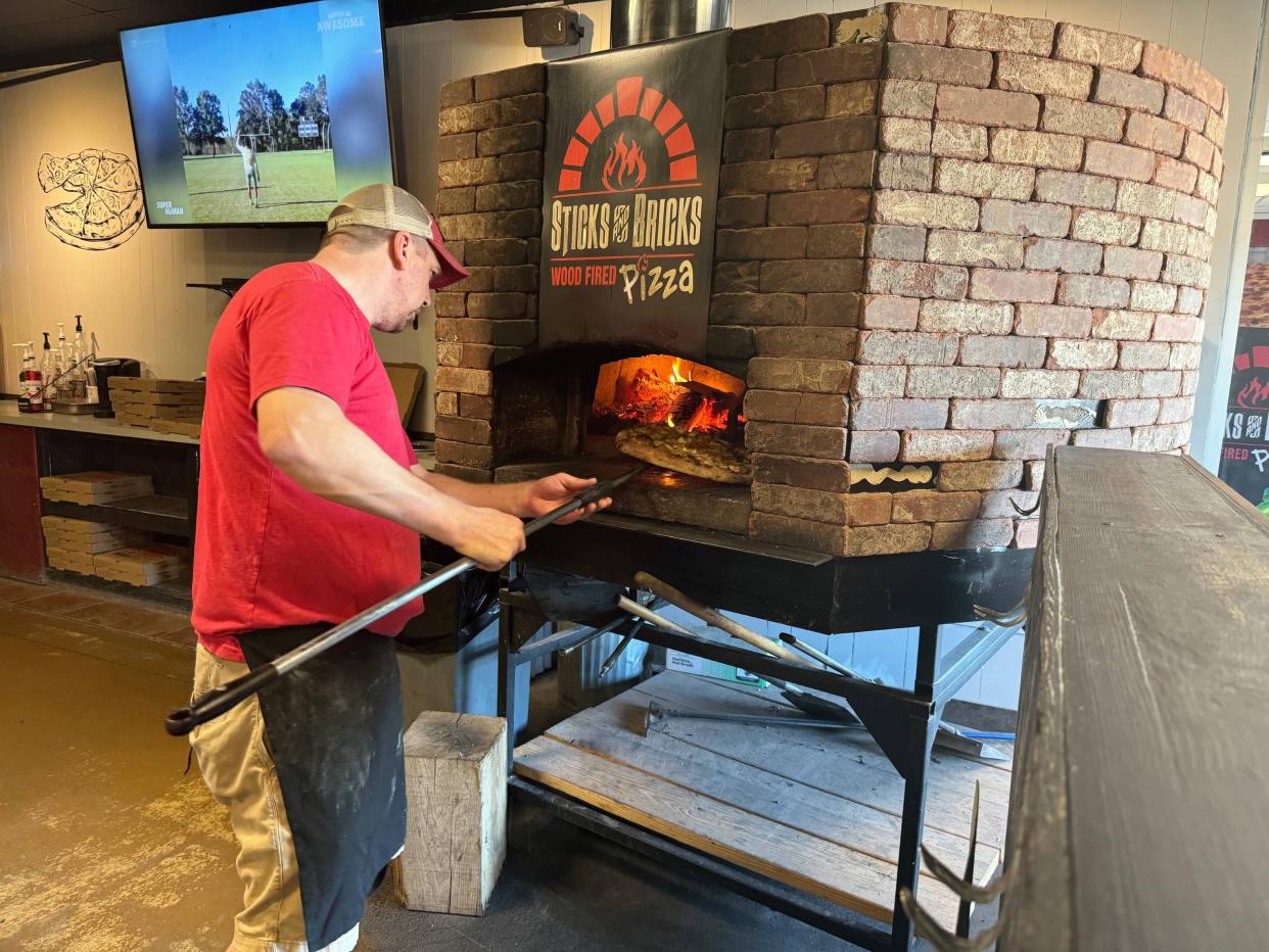 Russ Meyers, owner of Sticks 'n' Bricks pizza, 1301 E Grandview Blvd., uses actual burning wood to cook pizzas.