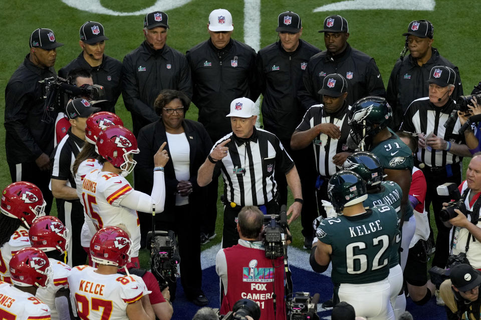 Kansas City Chiefs and Philadelphia Eagles players stand at midfield for the coin toss prior to the NFL Super Bowl 57 football game, Sunday, Feb. 12, 2023, in Glendale, Ariz. (AP Photo/Charlie Riedel)