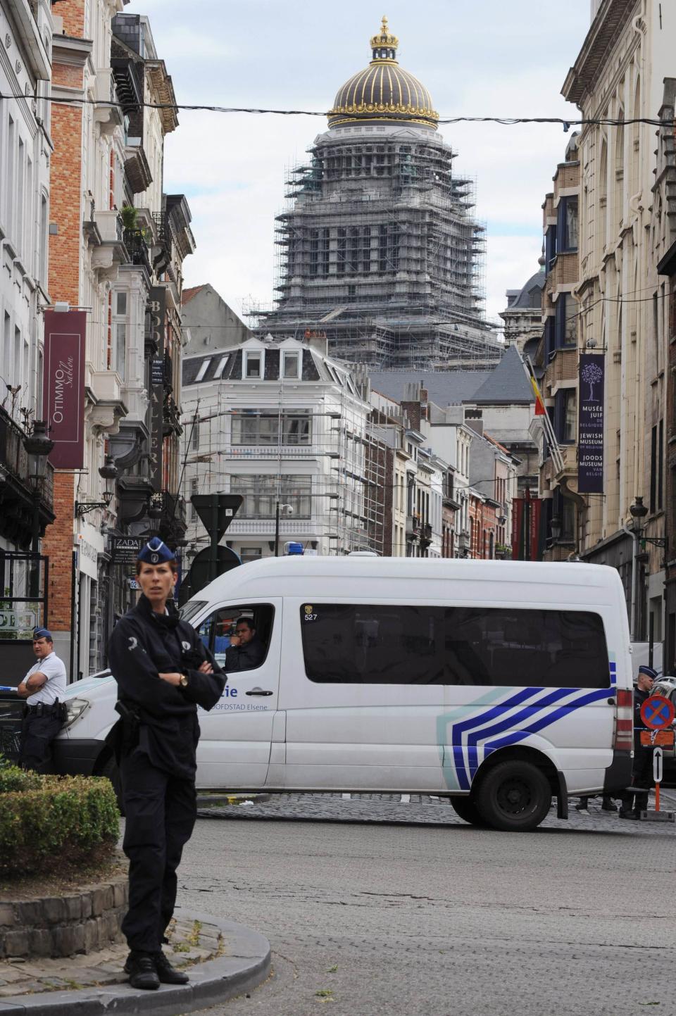 A policewoman and a police vehicle are seen at the site of a shooting in Brussels