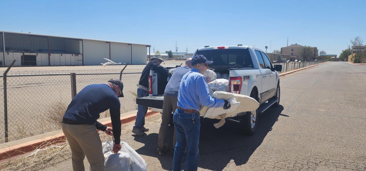 Volunteers with Keep Amarillo Clean load trash on a truck Monday near Amarillo Boulevard in West Amarillo.