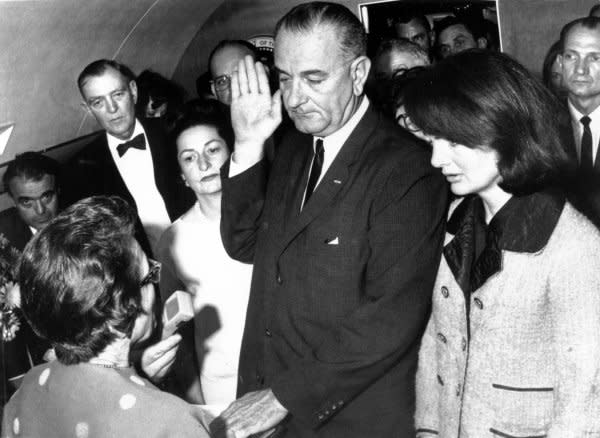 Flanked by Jackie Kennedy (R) and his wife, Ladybird Johnson, Vice President Lyndon Johnson is sworn in as president by Dallas U.S. District Judge Sarah T. Hughes (L) on November 22, 1963 aboard Air Force One following President John F. Kennedy's assassination. File Photo by Cecil Stoughton/JFK Library