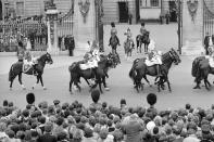 FILE - In this file photo dated June 13, 1964, Britain's Queen Elizabeth II and Prince Philip, left, take the salute as the Sovereign Escort of the Household Cavalry ride past Buckingham Palace in London. The ceremony marked the Queen's official birthday, her 38th, and the Colour trooped was that the First Battalion of the Coldstream Guards. Prince Philip who died Friday April 9, 2021, aged 99, lived through a tumultuous century of war and upheavals, but he helped forge a period of stability for the British monarchy under his wife, Queen Elizabeth II. (AP Photo, FILE)