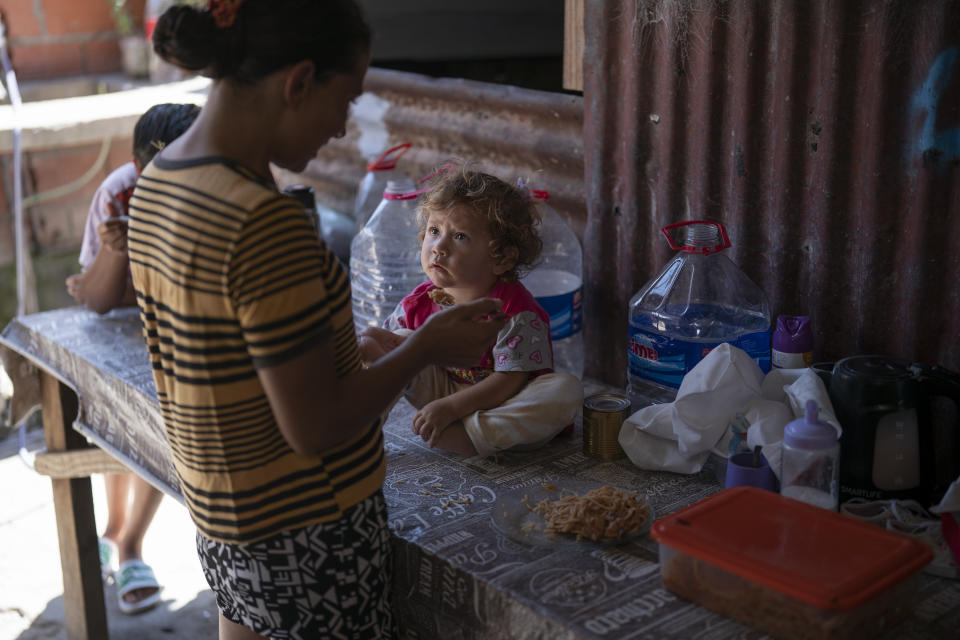 Yohanna Torres feeds her 2-year-old daughter Luján with food she received from a soup kitchen, on the outskirts of Buenos Aires, Wednesday, Feb. 21, 2024. Most of the social assistance money Torres receives, an equivalent of $200 per month, is used to care for Luján, who suffers from the respiratory consequences of COVID-19 that she contracted a few weeks after birth. (AP Photo/Victor R. Caivano)