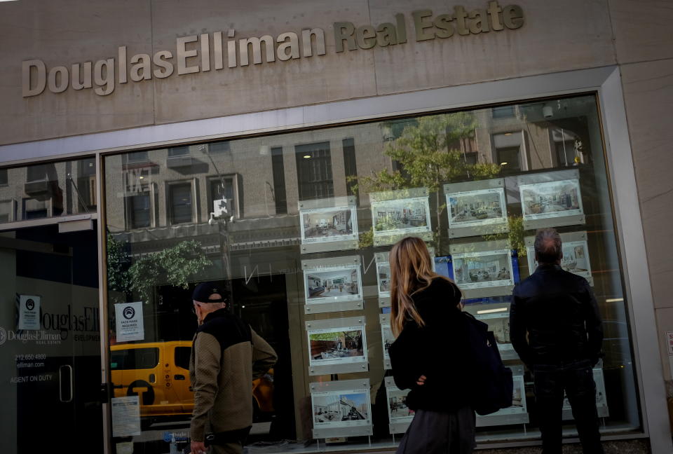 A man looks at advertisements for luxury apartments and homes in the window of a Douglas Elliman Real Estate sales business in Manhattan's upper east side neighborhood in New York City. (Credit: Mike Segar, Reuters)