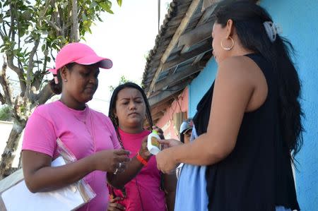 Health workers hand out mosquito repellent to a pregnant woman during a campaign to fight the spread of Zika virus in Soledad municipality near Barranquilla, Colombia, in this February 1, 2016 handout photo supplied by the Soledad Municipality. REUTERS/Aleydis Coll/Soledad Municipality/Handout via Reuters