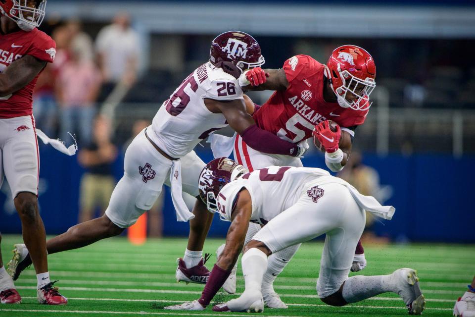Arkansas running back Raheim Sanders (5) is tackled by Texas A&M defensive back Demani Richardson (26) during the second quarter at AT&T Stadium.