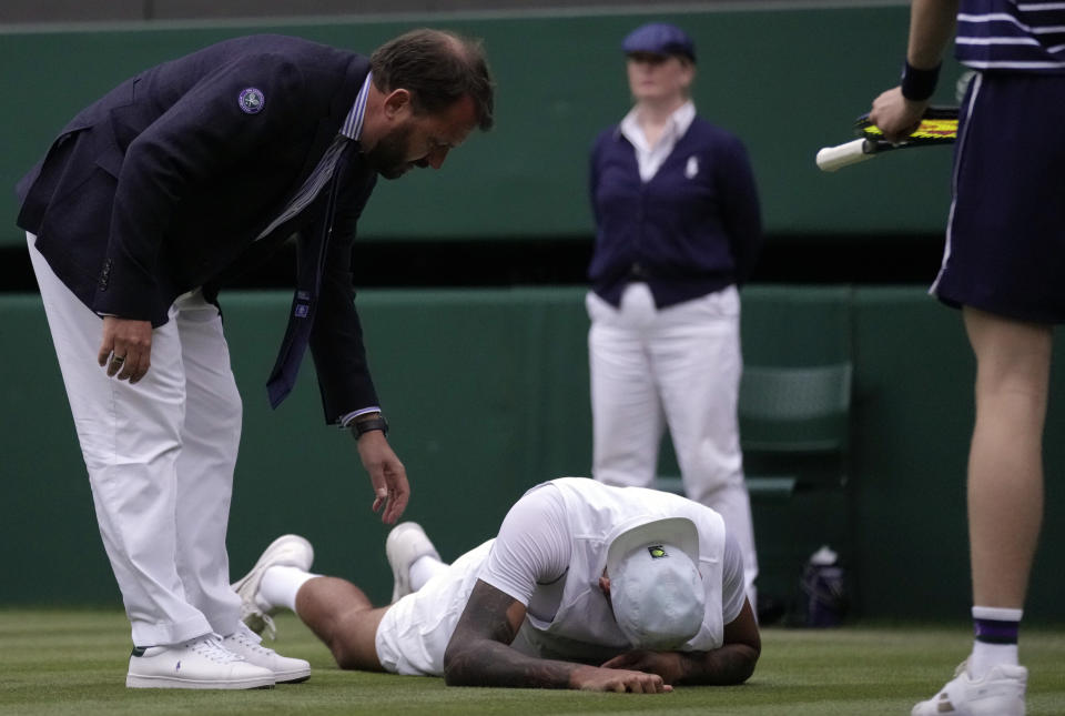 Australia's Nick Kyrgios on the ground during his third round men's singles match against Greece's Stefanos Tsitsipas on day six of the Wimbledon tennis championships in London, Saturday, July 2, 2022. (AP Photo/Kirsty Wigglesworth)