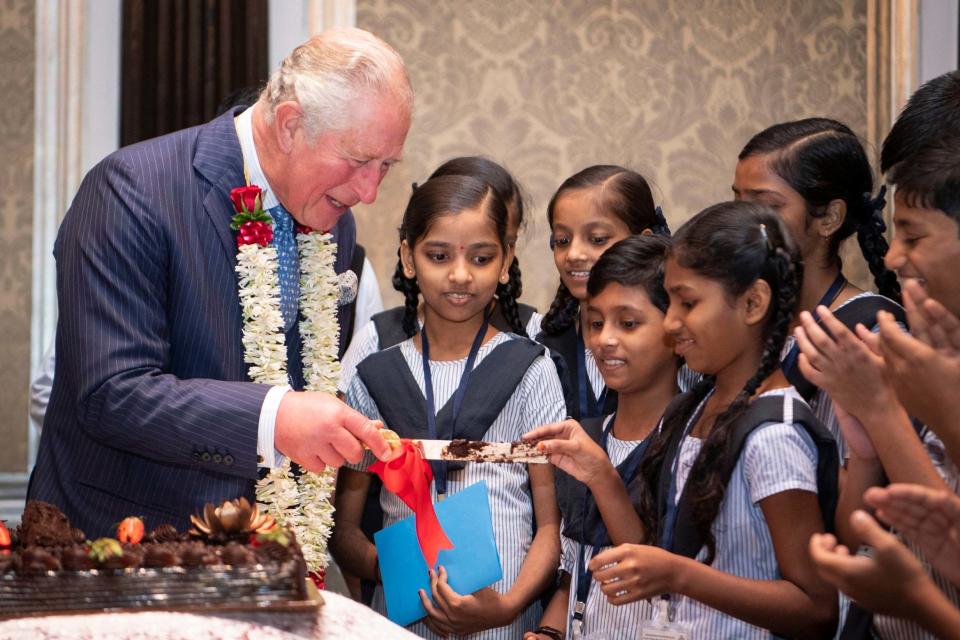 The Prince of Wales offers a piece of birthday cake to a schoolgirl on Thursday (Victoria Jones/PA)