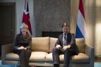 British Prime Minister Theresa May, left, and Dutch Prime Minister Mark Rutte pose for photographers at the start of a meeting in The Hague, Netherlands, Tuesday, Dec. 11, 2018. Facing almost certain defeat, Prime Minister May on Monday postponed a vote in Parliament on her Brexit deal, saying she would go back to European Union leaders to seek changes to the divorce agreement. (AP Photo/Peter Dejong, Pool)