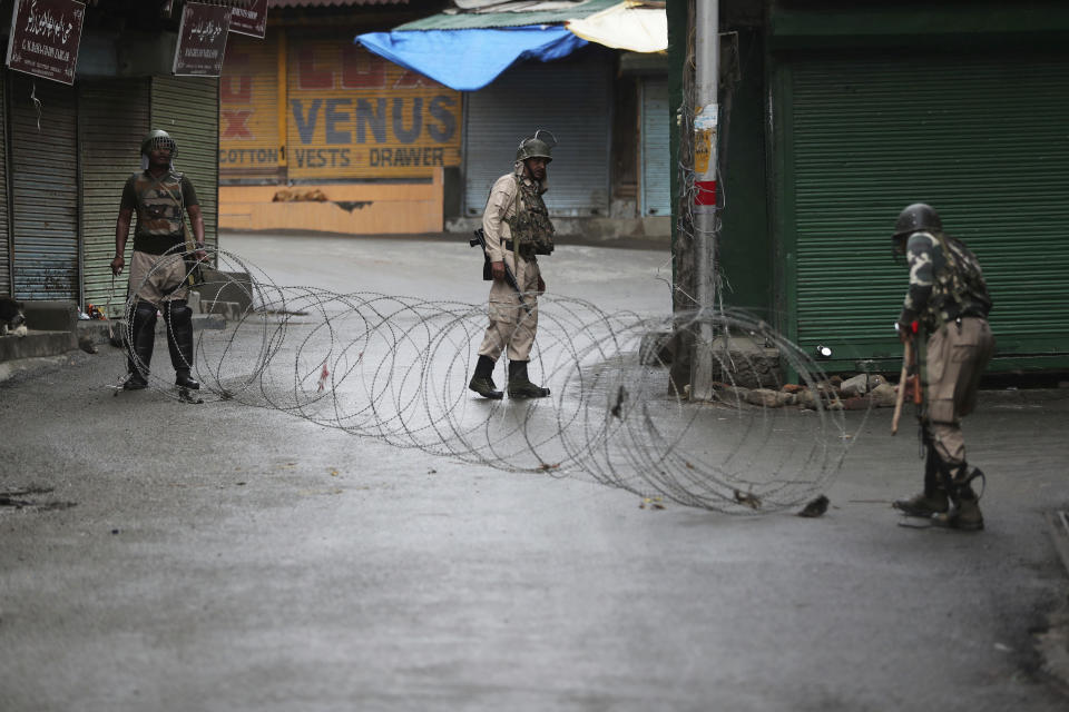 FILE - In this Aug. 10, 2019, file photo, Indian paramilitary soldiers close a street using barbed wire in Srinagar, Indian controlled Kashmir. India on Thursday, Oct. 31, 2019, formally implemented legislation approved by its Parliament in early August that removes Indian-controlled Kashmir's semi-autonomous status and begins direct federal rule of the disputed area amid a harsh security lockdown and widespread public disenchantment. (AP Photo/Mukhtar Khan, File)
