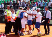 Tennis - Argentina v Italy - Davis Cup World Group First Round - Parque Sarmiento stadium, Buenos Aires, Argentina - 6/2/17. Argentina's team physical therapist Mariano Seara is grabbed by a security guard as he tries to confront Italy's sparring player Alessandro Giannessi after Italy's Fabio Fognini defeated Argentina's Guido Pella. REUTERS/Marcos Brindicci