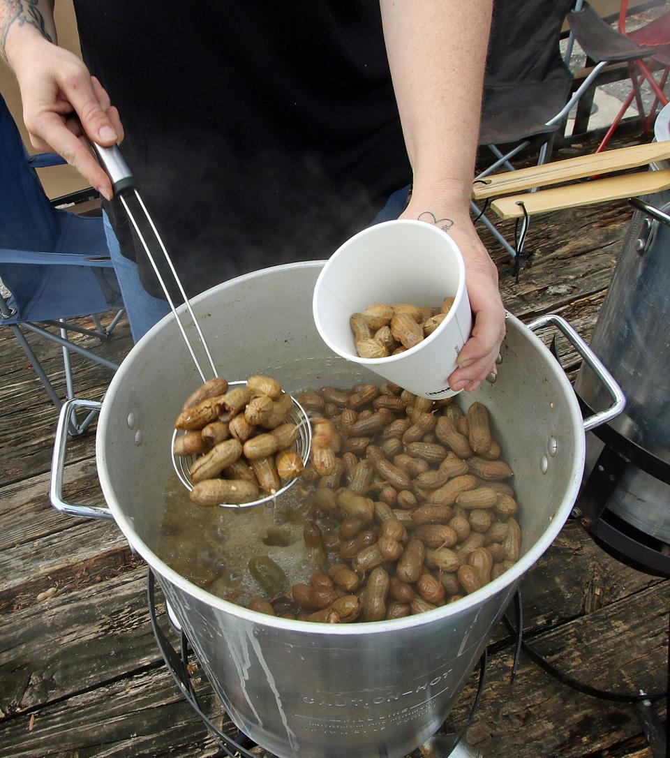 Kimberly “Mama Kim” Usery-Pettis loads a cup with dill Pickle boiled peanuts Thursday afternoon, Oct. 12, 2023, at the corner of Hickory Grove Road and Woodlawn Street.