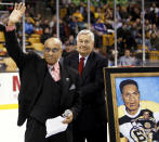 FILE - In this Jan. 19, 2008, file photo, former Boston Bruins hockey player Willie O'Ree waves to the crowd in Boston after being honored on the 50th anniversary of breaking the color barrier in the NHL after the first period of the Bruins hockey game against the New York Rangers in Boston. Looking on is Bruins legend John Bucyk. The Boston Bruins say they are retiring the jersey of Willie O’Ree, who broke the NHL’s color barrier. O’Ree will have his jersey honored prior to the Bruins’ Feb. 18 game against the New Jersey Devils. He became the league’s first Black player when he suited up for Boston on Jan. 18, 1958 against the Montreal Canadiens, despite being legally blind in one eye.(AP Photo/Winslow Townson, File)