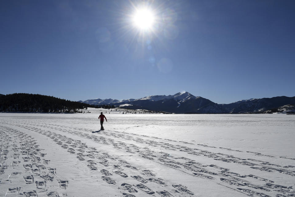 In this photo taken Jan. 7, 2020, British artist Simon Beck creates a massive geometrical design on a reservoir near Silverthorne, Colo. Beck uses snowshoes, a compass and his background as a cartographer and competitive orienteer to create snow and sand drawings around the world. (AP Photo/Thomas Peipert)