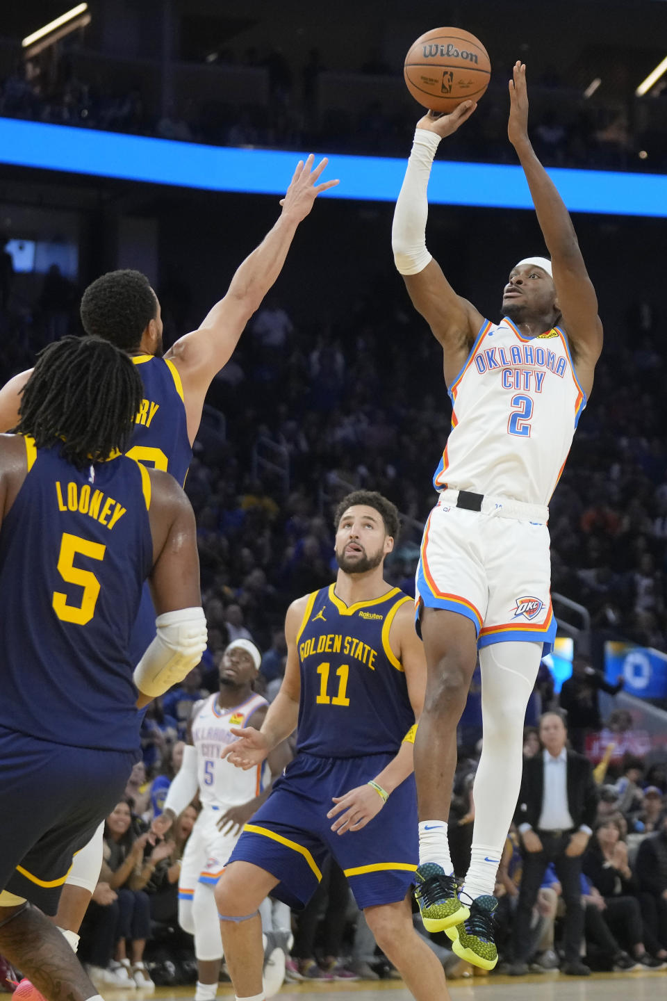 Oklahoma City Thunder guard Shai Gilgeous-Alexander (2) shoots against Golden State Warriors guard Stephen Curry, top left, forward Kevon Looney (5) and guard Klay Thompson (11) during the first half of an NBA basketball game in San Francisco, Saturday, Nov. 18, 2023. (AP Photo/Jeff Chiu)