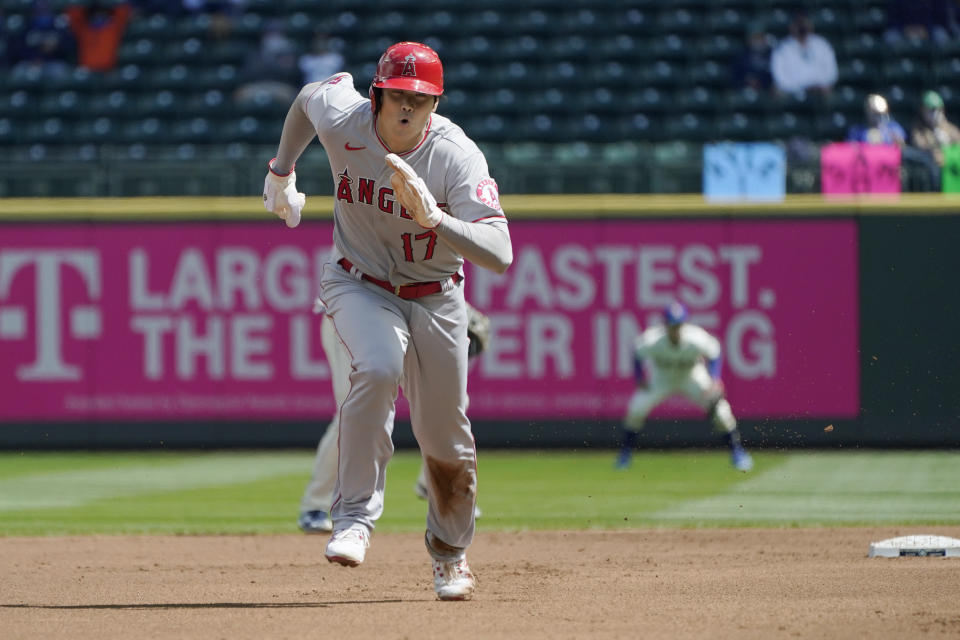 Los Angeles Angels' Shohei Ohtani (17) takes off to safely steal third base during the first inning of a baseball game against the Seattle Mariners, Sunday, May 2, 2021, in Seattle. (AP Photo/Ted S. Warren)