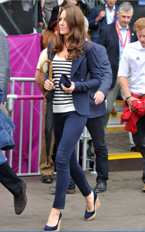 Kate’s navy blazer, pants, wedges, and clutch could easily be dull but her striped shirt pulls it together. We also can't help but notice that the umbrella is one her best unintentional accessories. Here the Duchess walks to her seat prior to the Show Jumping Eventing Equestrian on Day 4 of the London Games.