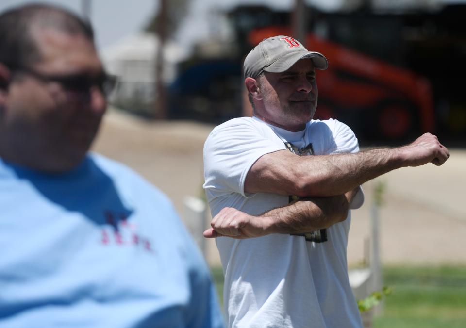 Geoffrey Esper, right, stretches before the egg roll competitive eating competition, Saturday, June 11, 2022, at Alcove Farms. Esper is number two in the world in competitive eating. 