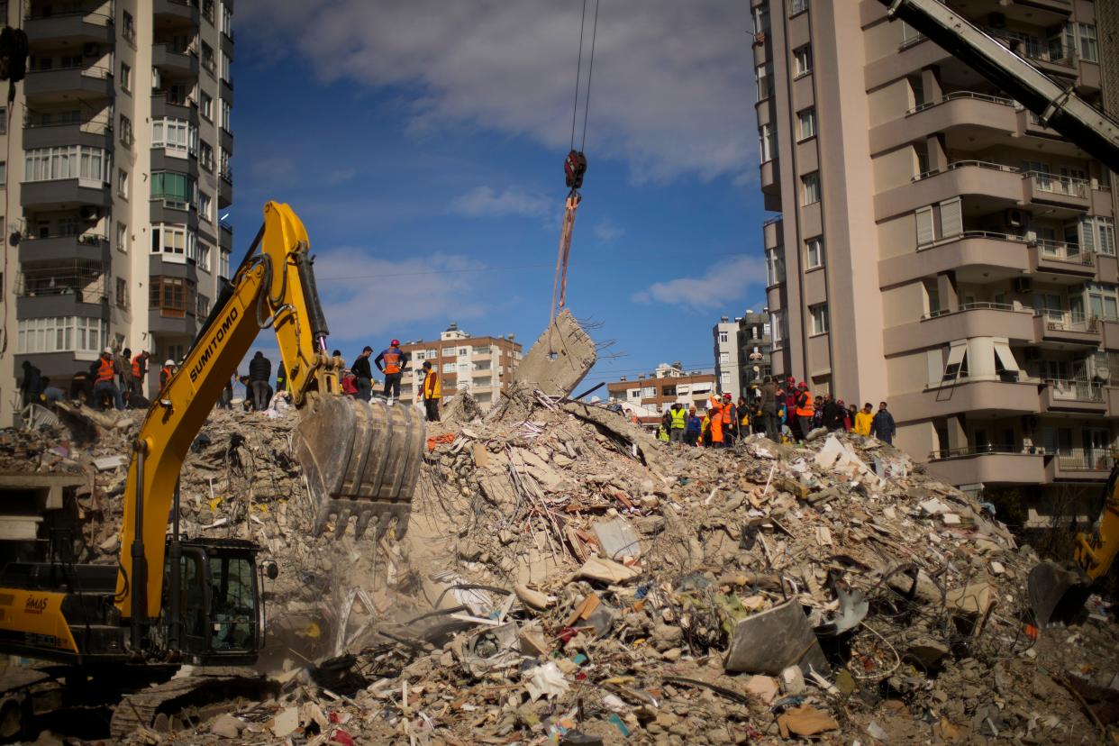 Emergency rescue members search for people in a destroyed building in Adana, Turkey, Tuesday, Feb. 7, 2023. Rescuers raced Tuesday to find survivors in the rubble of thousands of buildings brought down by a powerful earthquake and multiple aftershocks that struck eastern Turkey and neighboring Syria.