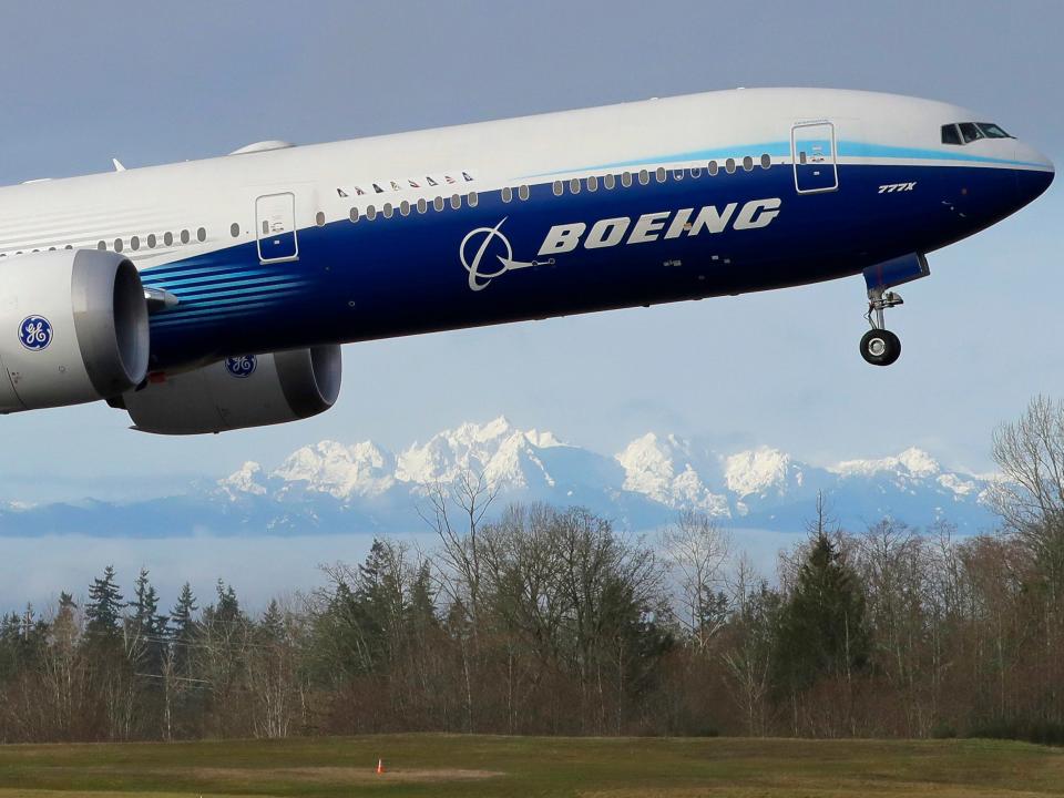 FILE - In this Jan. 25, 2020, file photo a Boeing 777X airplane takes off on its first flight with the Olympic Mountains in the background at Paine Field in Everett, Wash. Boeing Co. reports financial results on Wednesday, Jan. 29. (AP Photo/Ted S. Warren, File)