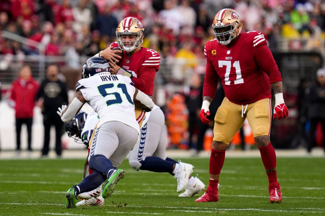 Seattle Seahawks linebacker Bruce Irvin (51) sacks San Francisco 49ers quarterback Brock Purdy as offensive tackle Trent Williams (71) looks on during the first half of an NFL wild card playoff football game in Santa Clara, Calif., Saturday, Jan. 14, 2023. (AP Photo/Godofredo A. Vásquez)