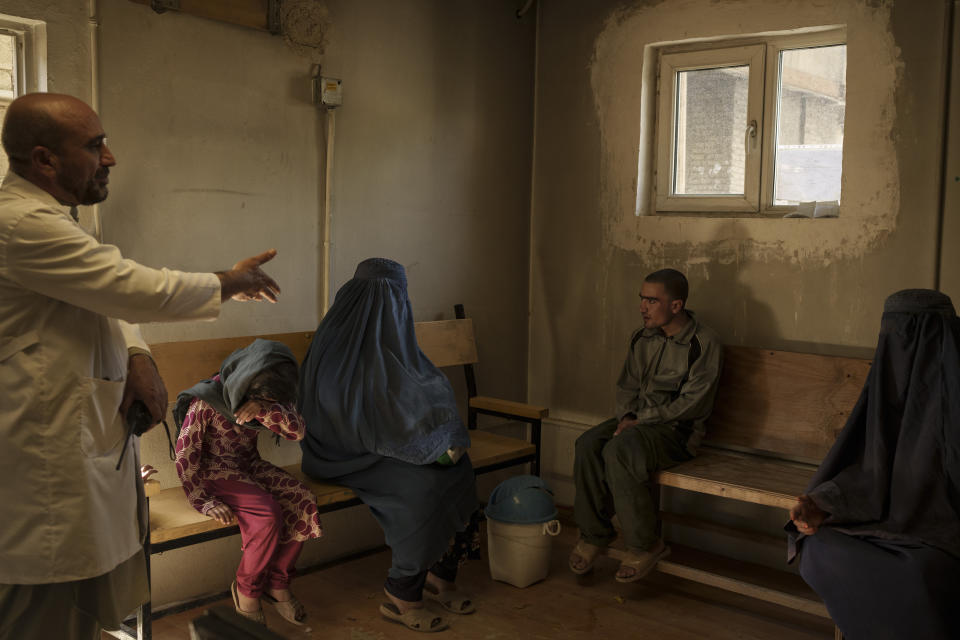 Dr. Wahedullah Koshan, left, gestures as he talks to Sitara, center, after she reunited with her 21-year-old son who was taken to the Avicenna Medical Hospital for Drug Treatment during a Taliban raid in Kabul, Afghanistan, Monday, Oct. 4, 2021.